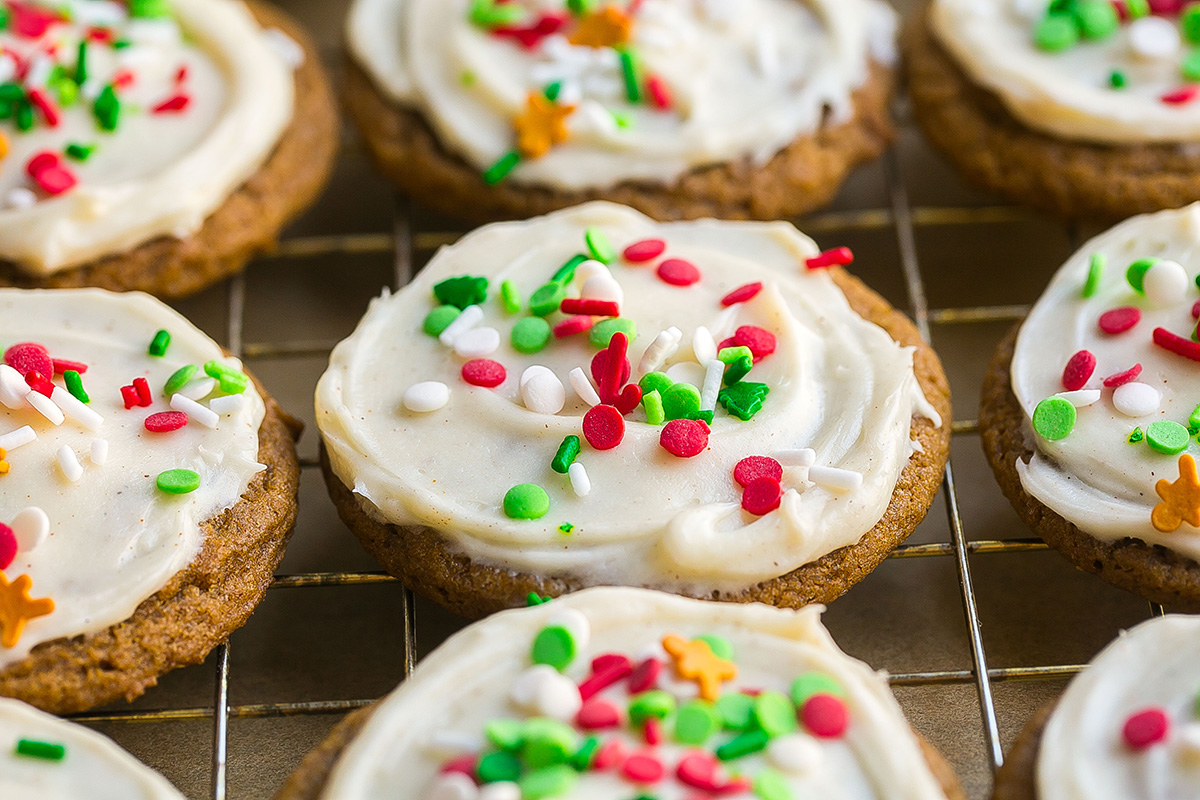 close up angled shot of frosted gingerbread cookies on cooling rack