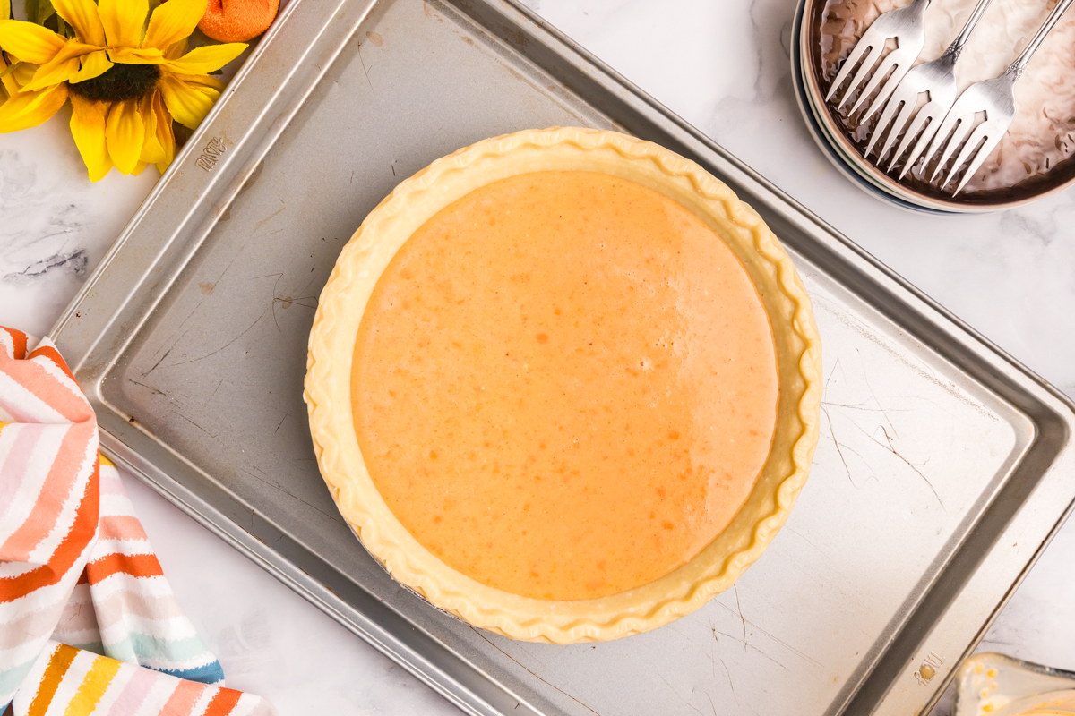 pie filling in pie crust on baking sheet