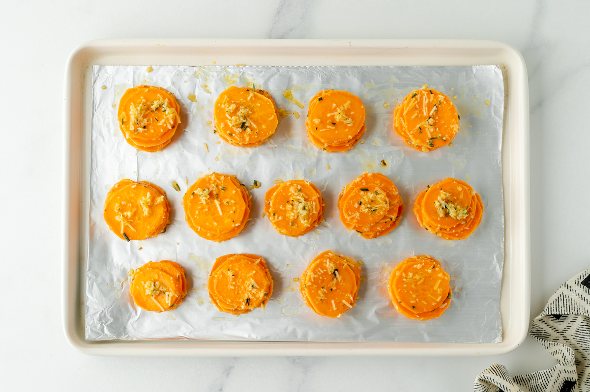 overhead shot of stacks of sweet potato slices on sheet pan