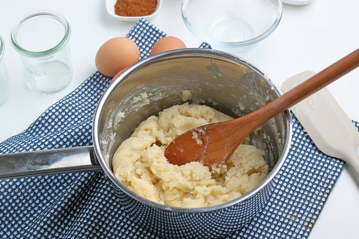 churro dough in pan with wooden spoon