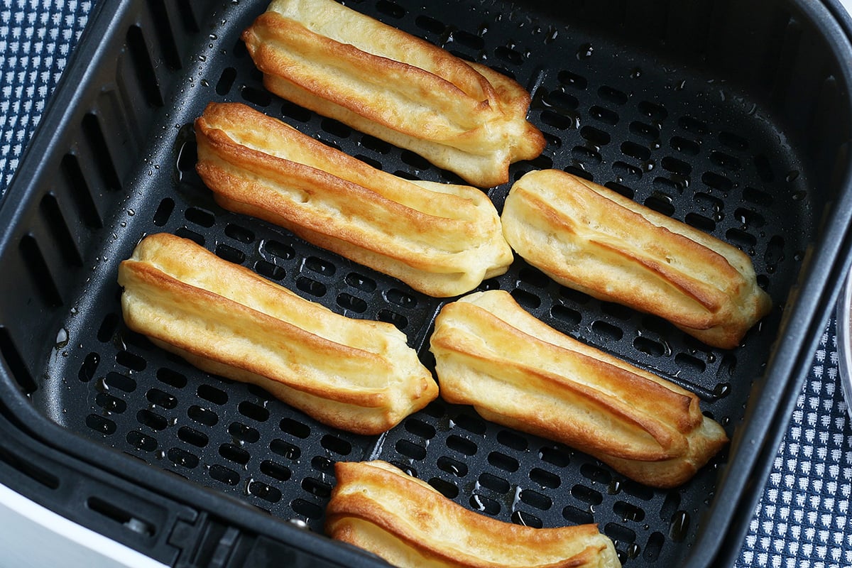 churro dough frying in air fryer basket