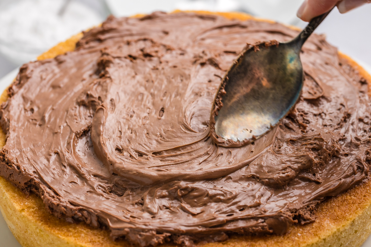 spoon spreading frosting onto cake