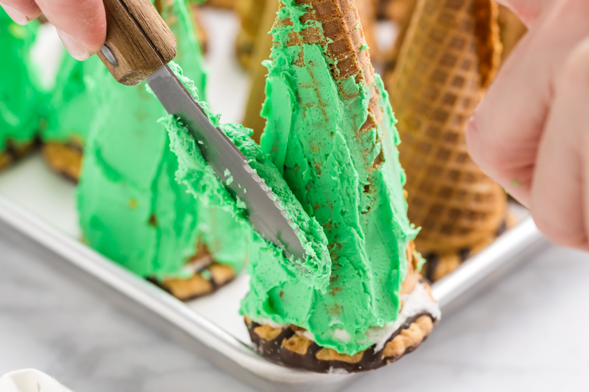 green icing spread onto cake cones