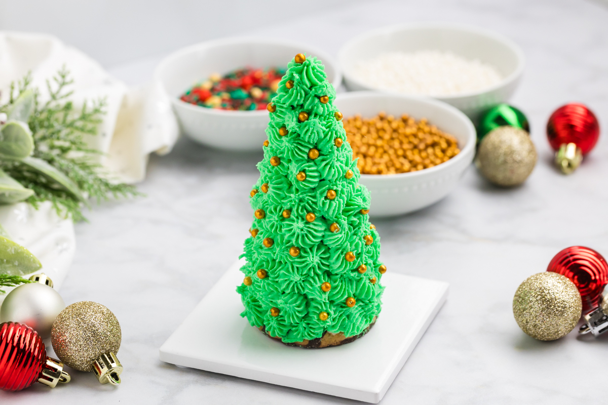 angled shot of christmas tree cake cone topped with gold sprinkles