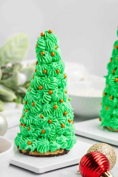 straight on shot of two christmas tree cake cones with gold decorations