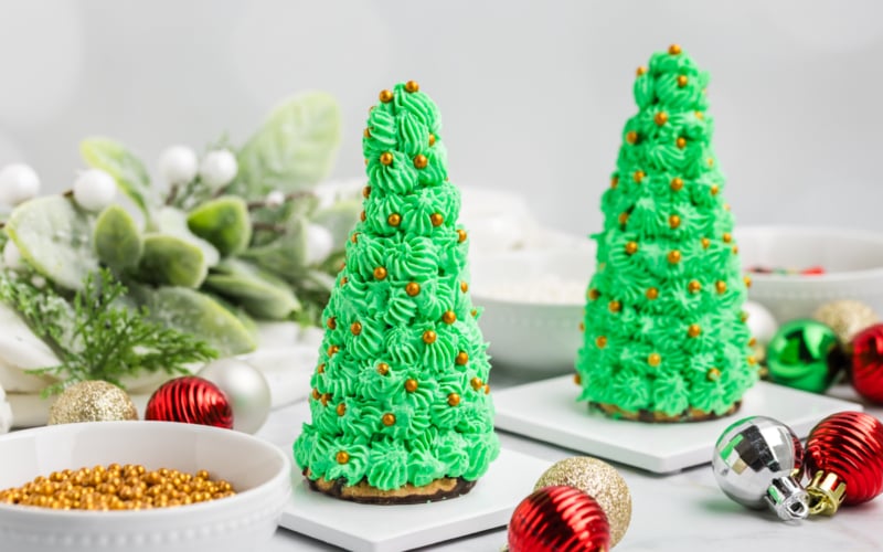 straight on shot of two christmas tree cake cones with gold decorations