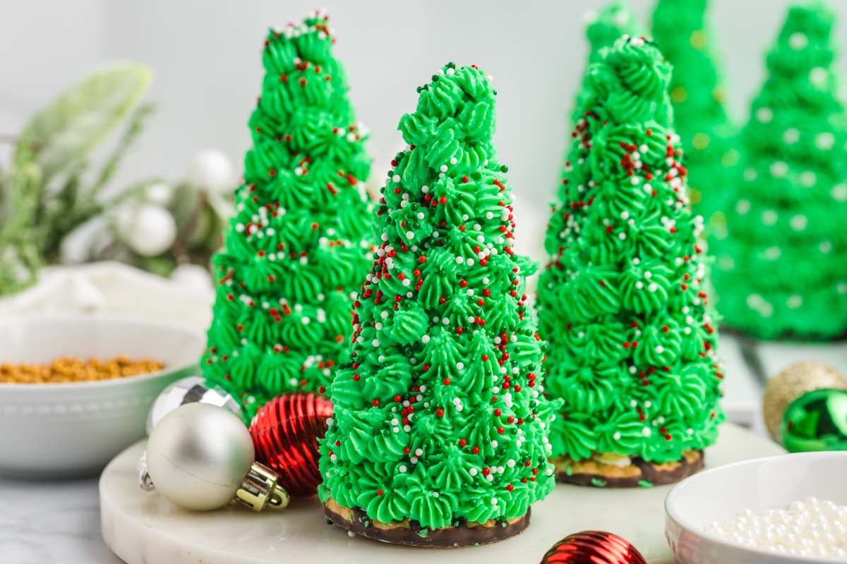 three christmas tree cake cones topped with red, green and white sprinkles