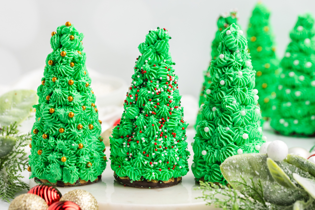 straight on shot of three decorated christmas tree cupcakes