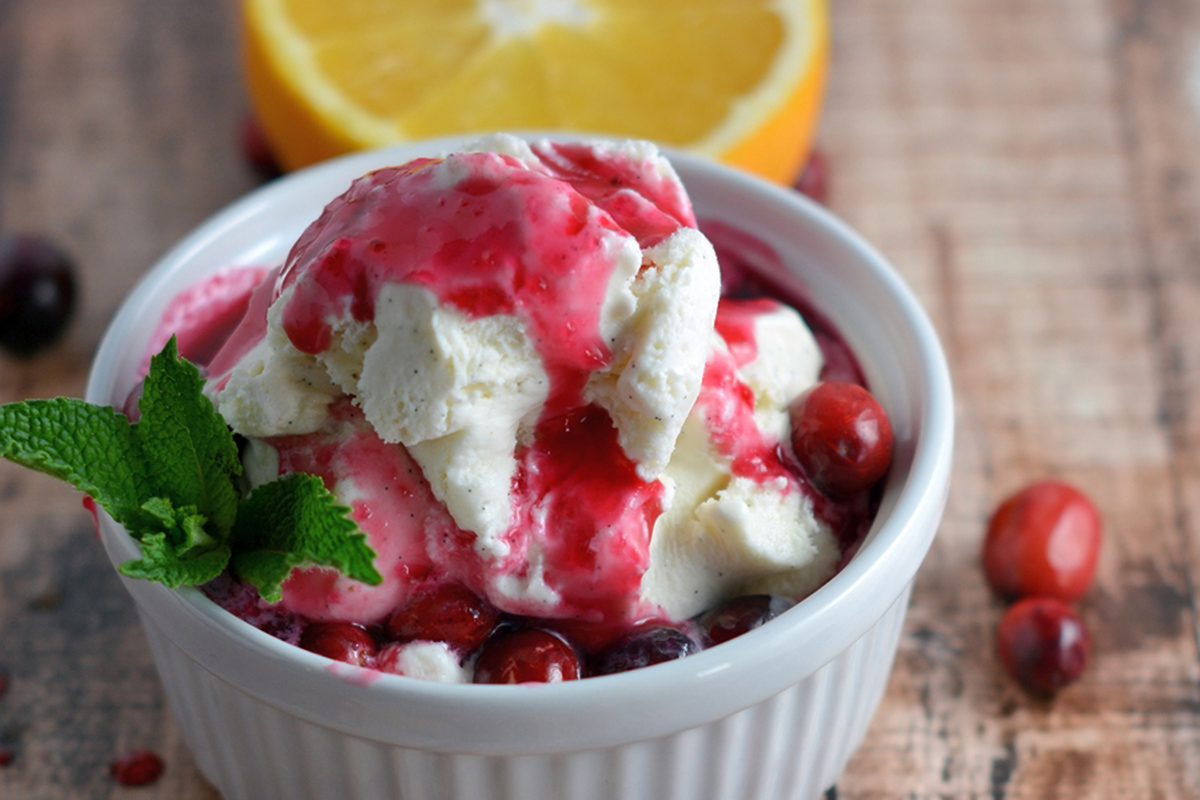 bowl of vanilla ice cream topped with cranberry syrup