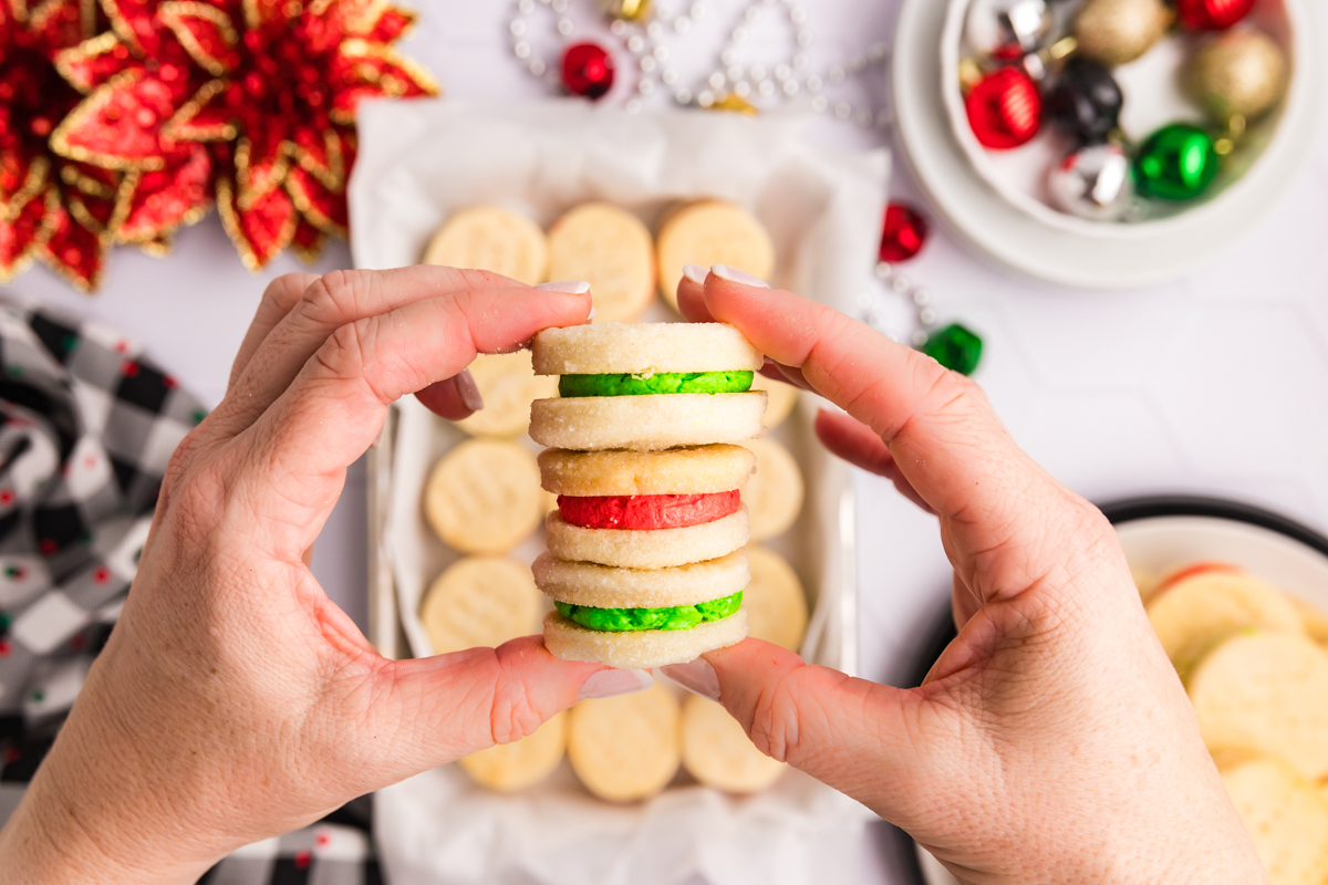 overhead shot of hands holding three cream wafer cookies