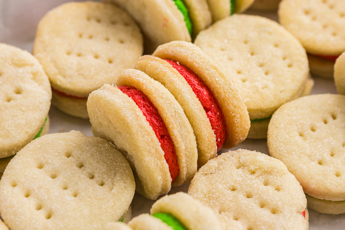 close up angled shot of christmas sandwich cookies on baking sheet