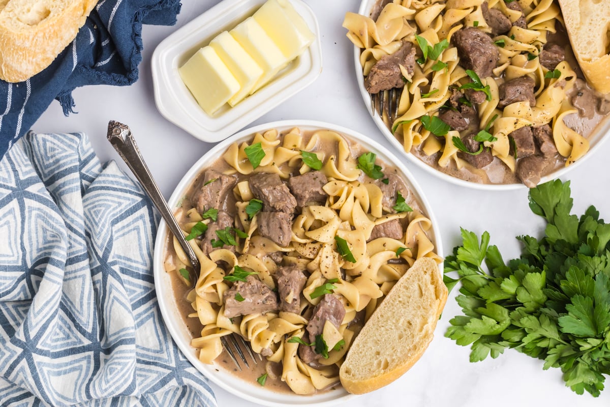 overhead shot of two plates of crock pot beef and noodles