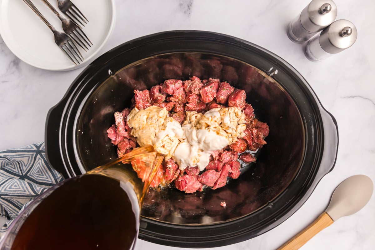 broth and soup added to cubed beef in a crock pot