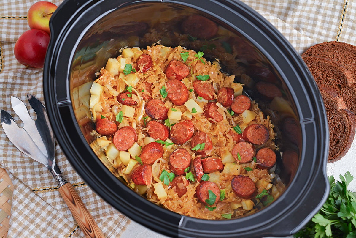 overhead shot of sauerkraut and sausage in a slow cooker