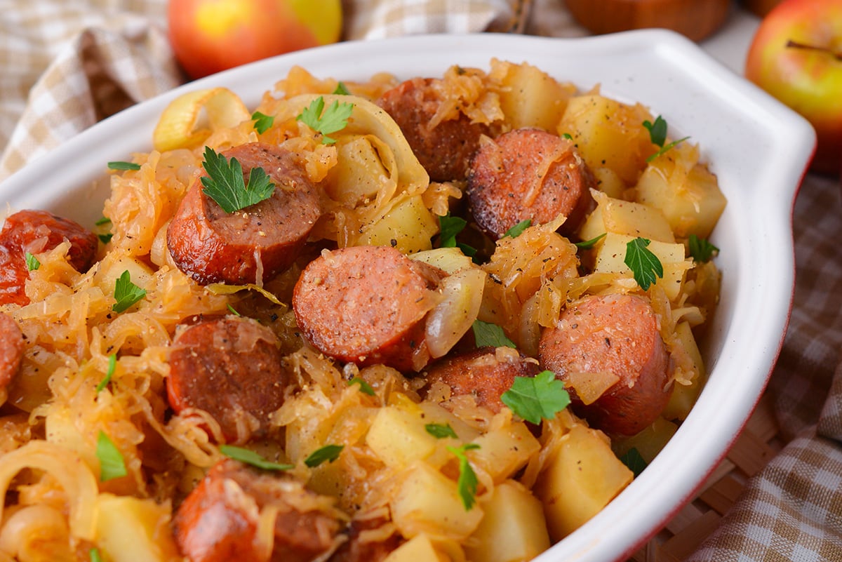 close up angled shot of crock pot sauerkraut and sausage