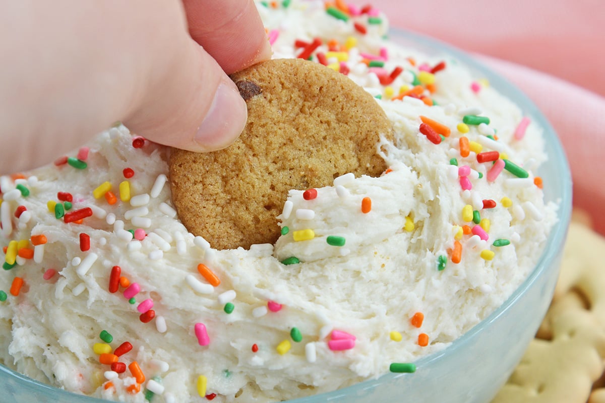 chocolate chip cookie dipping into funfetti dunkaroo dip