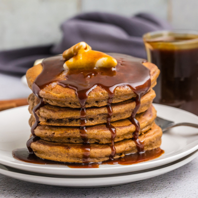 straight on shot of butter and syrup over stack of gingerbread pancakes