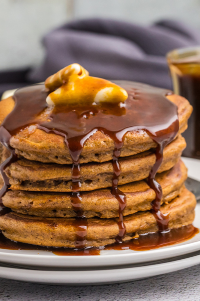 straight on shot of butter and syrup over stack of gingerbread pancakes