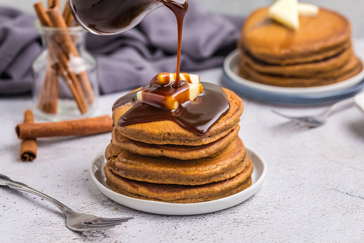 gingerbread syrup pouring over stack of pancakes