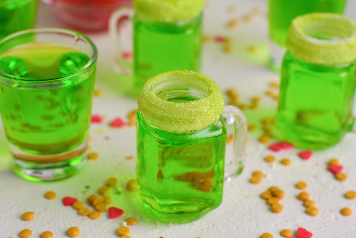 close up angled shot of green shots in shot glasses