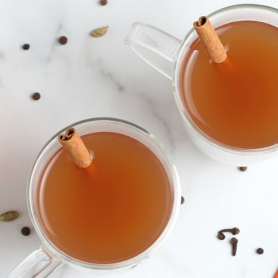 overhead shot of two mugs of mulled cider