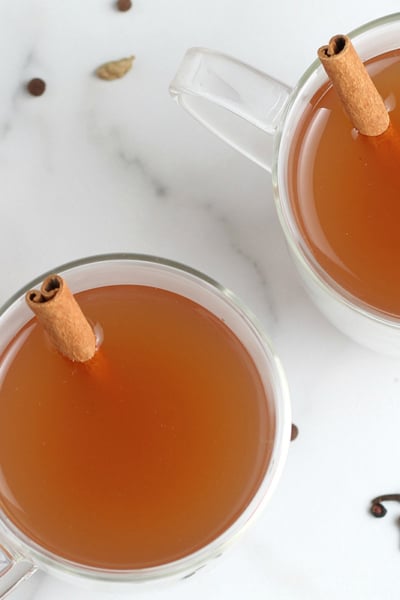 overhead shot of two mugs of mulled cider