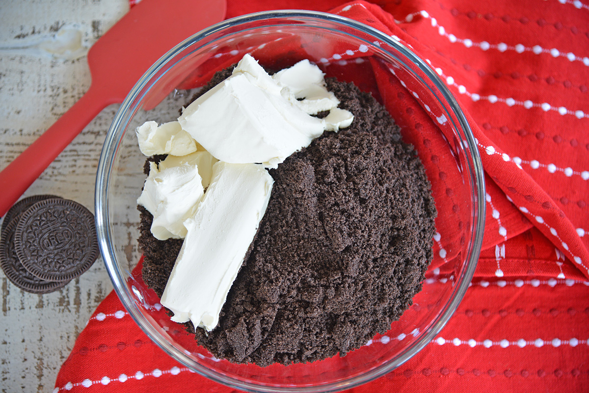 cream cheese in bowl of crushed oreos