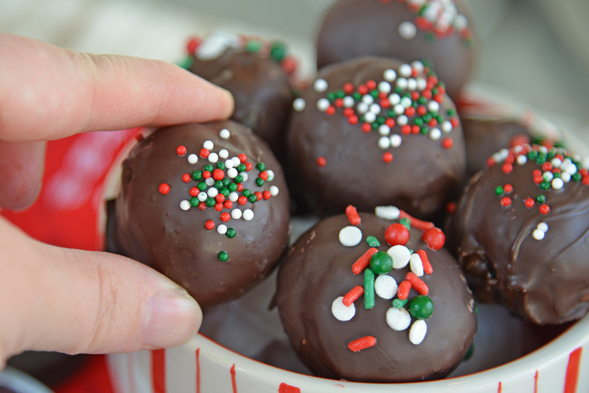 hand grabbing oreo cookie ball out of bowl