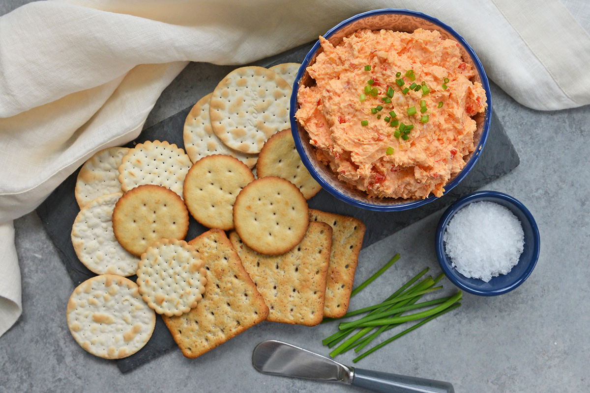 overhead shot of bowl of pimento cheese on platter with crackers