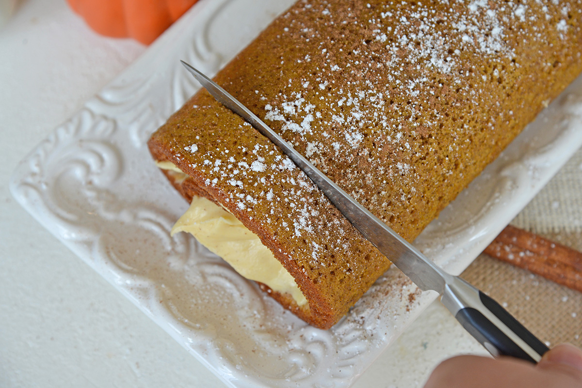 knife cutting into pumpkin cake roll