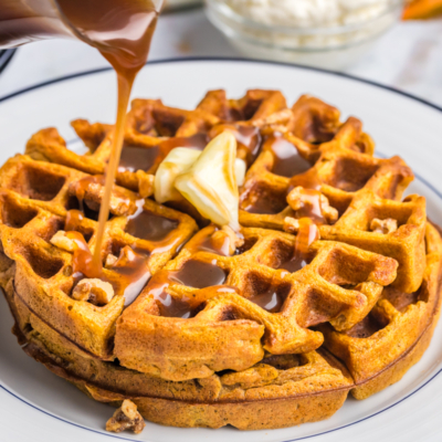 syrup pouring over two pumpkin waffles