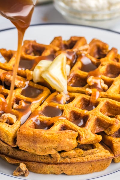 syrup pouring over two pumpkin waffles