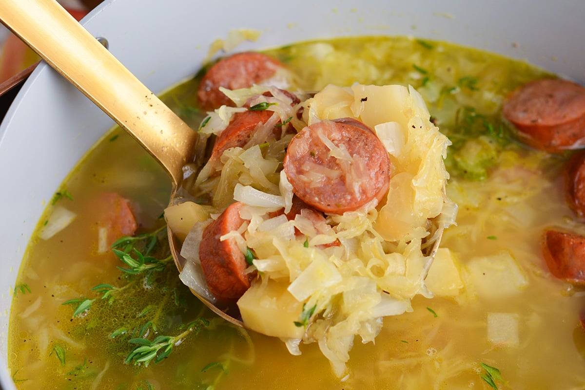 sausage and sauerkraut soup in ladle