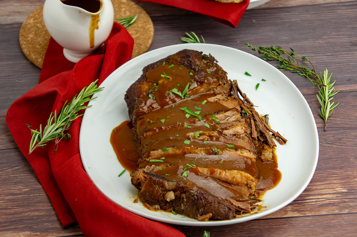 sliced brisket on plate topped with gravy