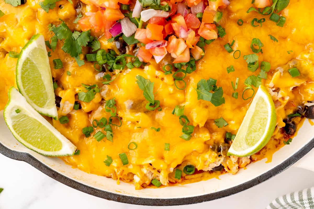 close up overhead shot of chicken enchilada casserole in skillet