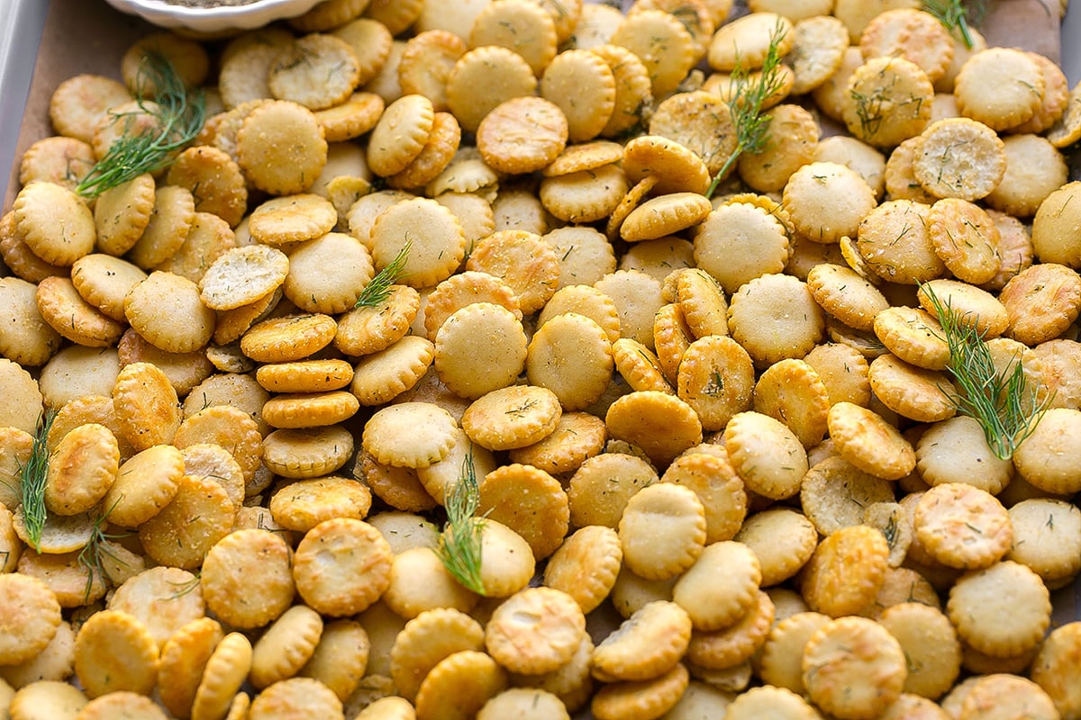 close up angled shot of dill seasoned oyster crackers on sheet pan