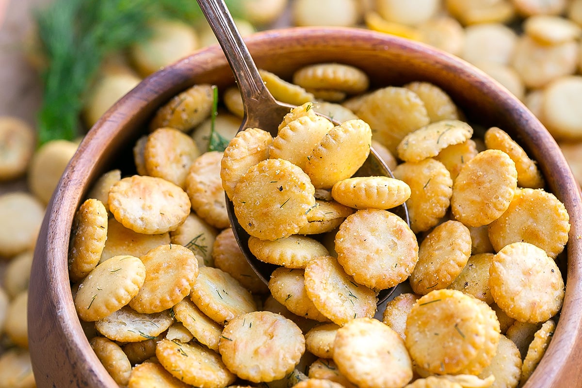 angled shot of spoon in bowl of dill oyster crackers