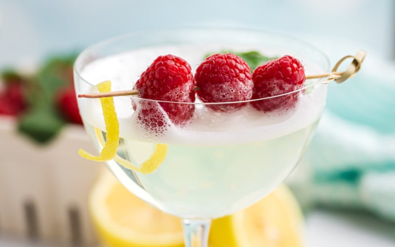 close up shot of raspberries in cocktail