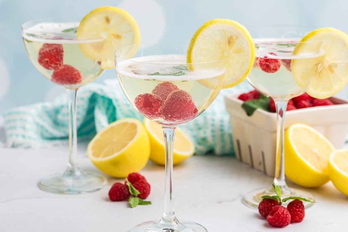 three elderflower cocktails with lemons and raspberries