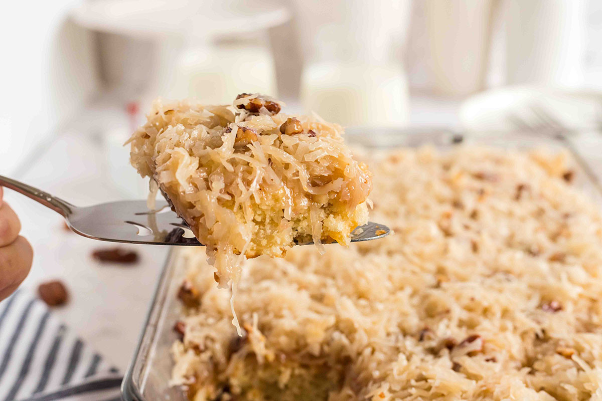 angled shot of slice of fruit cocktail cake on spatula