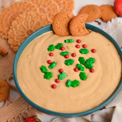 angled shot of bowl of gingerbread cake dip topped with sprinkles