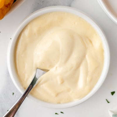 overhead shot of spoon in bowl of mustard aioli