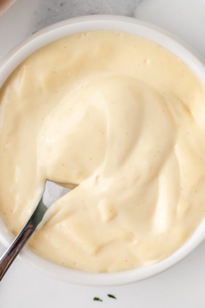 overhead shot of spoon in bowl of mustard aioli