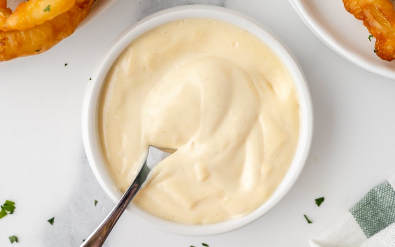 overhead shot of spoon in bowl of mustard aioli