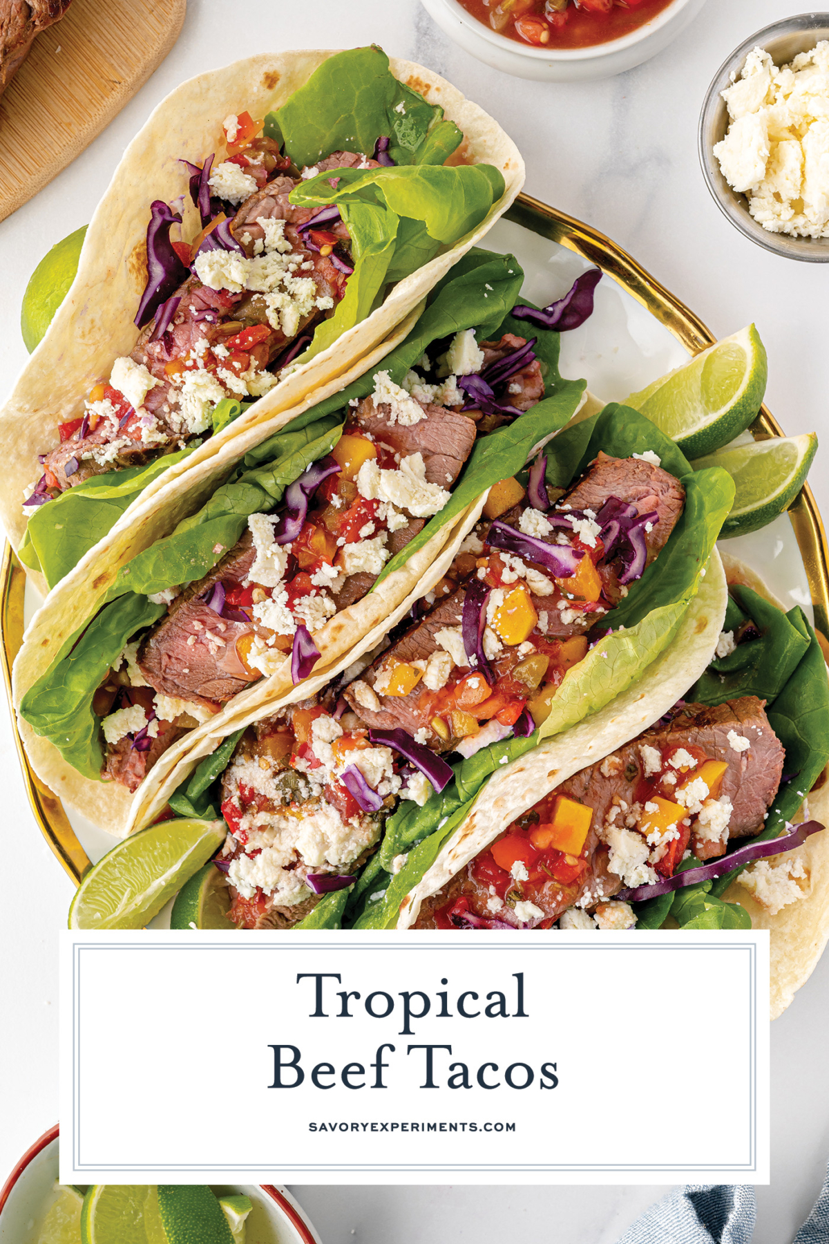 overhead shot of tropical beef tacos on platter with text overlay