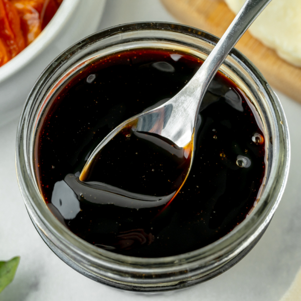 overhead shot of spoon in jar of balsamic glaze