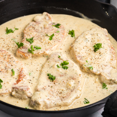 angled shot of skillet of creamy pork chops