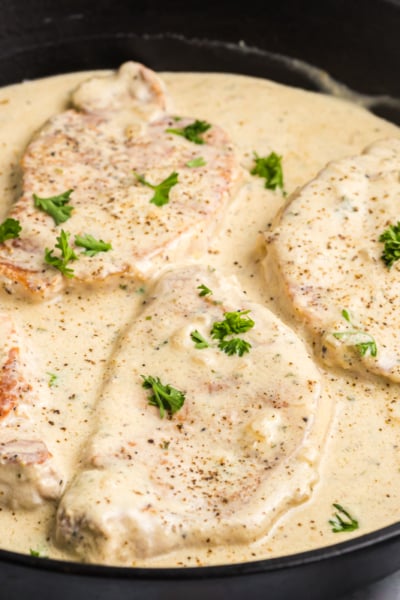 angled shot of skillet of creamy pork chops