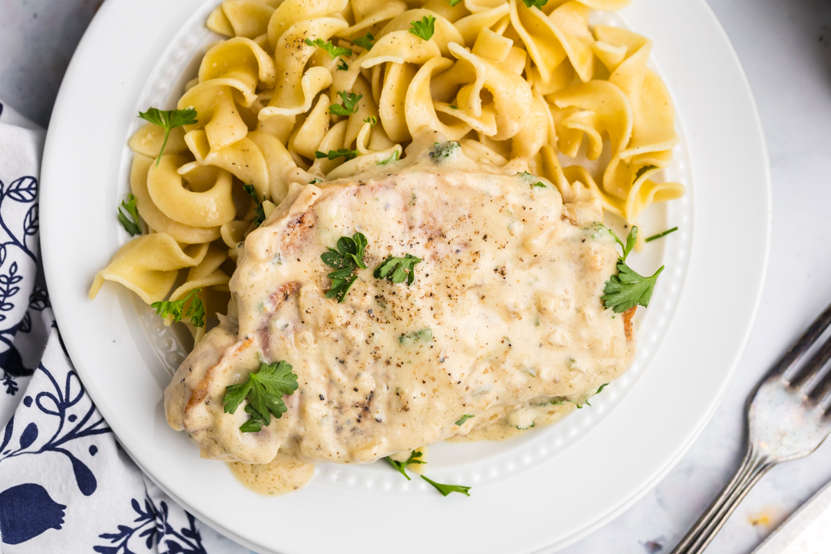 overhead shot of boursin pork chop on plate with noodles