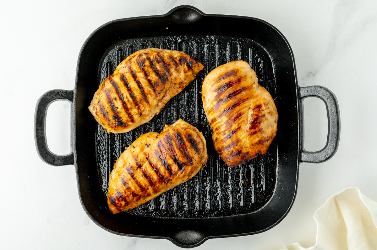 chicken cooking on cast iron skillet